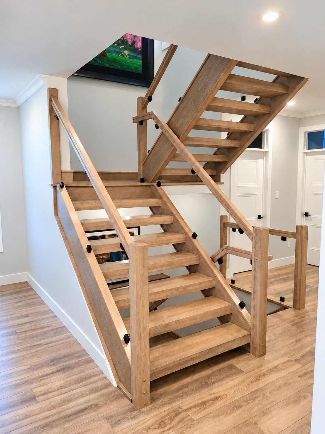 Modern oak staircase with glass railings in a bright hallway by StairTrim Design