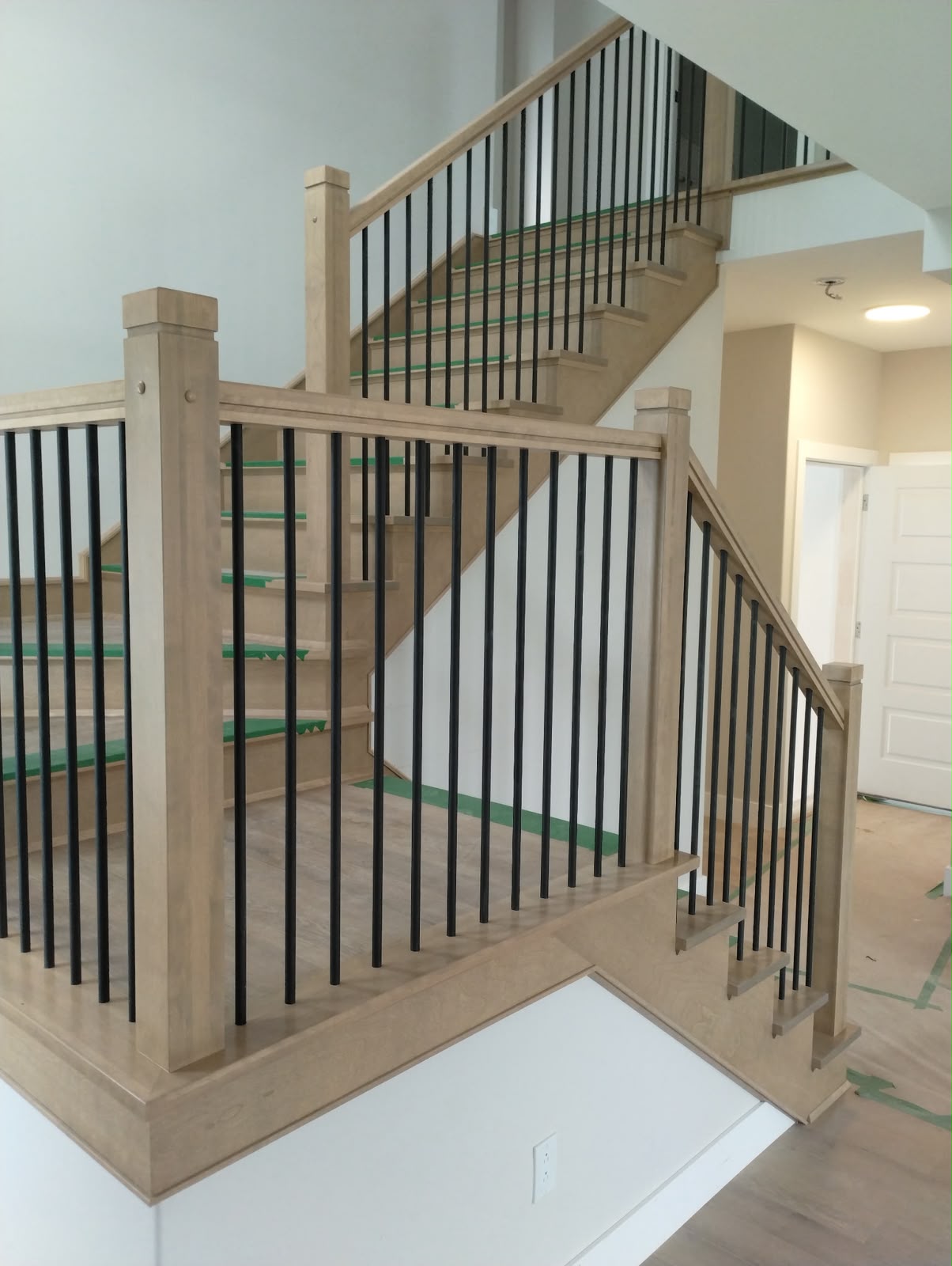 Custom hardwood staircase with black balusters by StairTrim Design