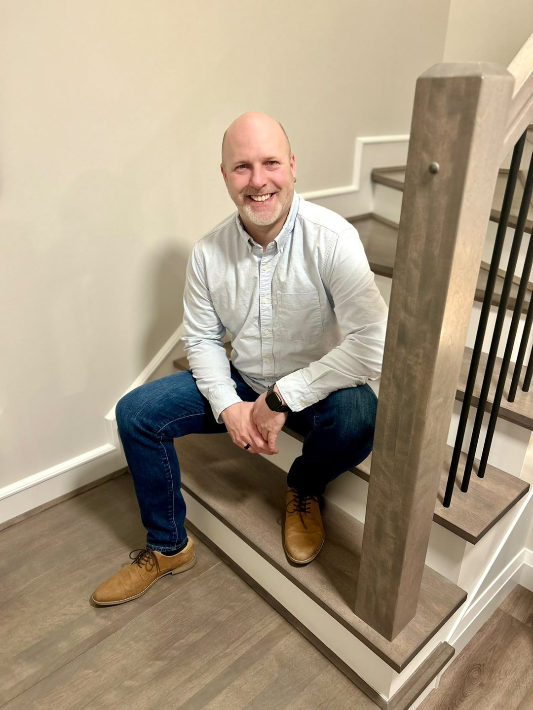Hughie O’Keefe, owner of StairTrim Design, seated on a staircase